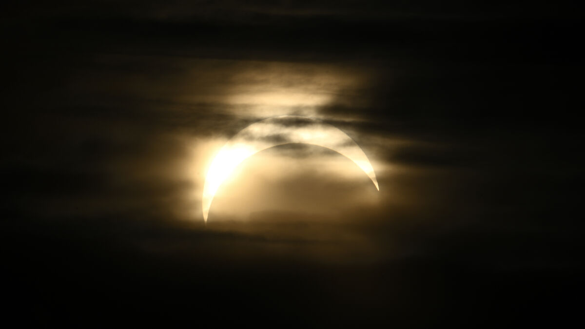 Hundreds gather in Stockholm to watch partial solar eclipse, despite clouds